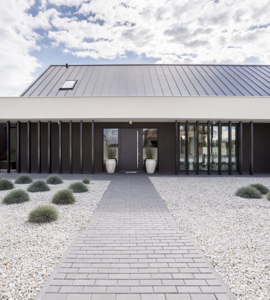 Pavement leading to modern house through the garden